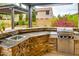 Outdoor kitchen with granite counters, stainless steel BBQ grill, and sink, great for outdoor cooking at 26926 N 55Th Ln, Phoenix, AZ 85083