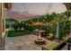 Inviting backyard with a built-in grill, fire pit, ambient lighting, and lush greenery at 2721 E Tamarisk St, Gilbert, AZ 85296