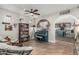 Open-concept living room with refinished piano, bookcase, and arched entryway leading to the kitchen at 2721 E Tamarisk St, Gilbert, AZ 85296