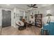 Bright living room with hardwood floors, ceiling fan, two papasan chairs, and a painted upright piano at 2721 E Tamarisk St, Gilbert, AZ 85296