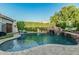 Backyard pool with a rock waterfall feature, landscaping, and a diving board at 2721 E Tamarisk St, Gilbert, AZ 85296