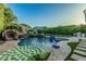 Backyard pool with a rock waterfall feature, spa, basketball hoop, and comfortable seating at 2721 E Tamarisk St, Gilbert, AZ 85296