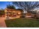 Spacious backyard featuring a patio with dining, a hammock, a grill, and a cozy fire pit surrounded by lush greenery at 2823 E Charlotte Dr, Phoenix, AZ 85024