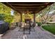 Outdoor dining area under a pergola with stone fireplace, outdoor grill, and manicured backyard at 2823 E Charlotte Dr, Phoenix, AZ 85024