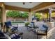 Cozy backyard patio with comfortable seating, elegant decor, outdoor grill, and lush trees in the background at 2823 E Charlotte Dr, Phoenix, AZ 85024