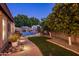 Backyard with a brick-paved path leading to the pool area, lush landscaping, and a view of the surrounding trees at 2823 E Charlotte Dr, Phoenix, AZ 85024