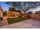 Inviting backyard featuring a patio with dining, a hammock, a grill, a cozy fire pit and mature trees at 2823 E Charlotte Dr, Phoenix, AZ 85024