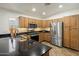 Well-lit kitchen with stainless steel appliances, wood cabinets, and dark granite countertops at 2823 E Charlotte Dr, Phoenix, AZ 85024