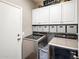 Modern laundry room with front-loading machines, white cabinets, and neatly organized storage bins at 2823 E Charlotte Dr, Phoenix, AZ 85024