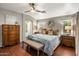 Cozy bedroom with wood floors, a ceiling fan, and an ensuite bathroom at 2823 E Charlotte Dr, Phoenix, AZ 85024