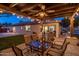 Outdoor dining area with a glass top table and seating, string lights, and a view of the backyard with a pool at 2823 E Charlotte Dr, Phoenix, AZ 85024