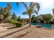 Spacious backyard featuring a sparkling pool, lush landscaping, and comfortable lounge seating under a sun umbrella at 3323 N 28Th St, Phoenix, AZ 85016