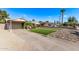 Inviting home exterior with a green artificial lawn, stone features, solar panels, carport, and desert landscaping at 3323 N 28Th St, Phoenix, AZ 85016