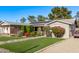 Charming home with a well-manicured lawn, colorful flower bushes, solar panels and a covered parking area at 3323 N 28Th St, Phoenix, AZ 85016