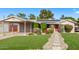 Charming single-story home with a well-manicured lawn, carport, and inviting red front door at 3323 N 28Th St, Phoenix, AZ 85016