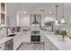 Modern, all-white kitchen featuring marble countertops, stainless steel appliances, and pendant lighting at 3323 N 28Th St, Phoenix, AZ 85016