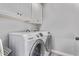 Bright laundry room with modern, front-loading washer and dryer beneath white cabinetry at 3323 N 28Th St, Phoenix, AZ 85016