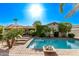 Relaxing backyard pool area featuring a brick surround, lounge chairs, and lush greenery under a bright, sunny sky at 3323 N 28Th St, Phoenix, AZ 85016