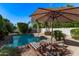 Relaxing pool area with striped lounge chairs under a sun umbrella, perfect for enjoying sunny days outdoors at 3323 N 28Th St, Phoenix, AZ 85016