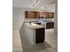 Bright kitchen featuring dark wood cabinets, white appliances, a breakfast bar, and track lighting at 3454 E Bellerive Pl, Chandler, AZ 85249