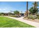Community pool featuring palm trees, green landscaping, and a shaded seating area at 3756 E Waite Ln, Gilbert, AZ 85295