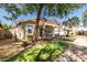Charming single-story home with a well-manicured lawn and mature trees providing shade on a sunny day at 3756 E Waite Ln, Gilbert, AZ 85295