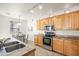 Kitchen with stainless steel appliances, wooden cabinets and view into the dining area at 3756 E Waite Ln, Gilbert, AZ 85295