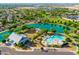 Aerial view of a community with a lake, pool, community center, and lush green landscaping at 4024 E Maplewood St, Gilbert, AZ 85297