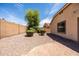 Desert backyard with gravel landscaping, mature trees, and a block wall providing privacy at 4024 E Maplewood St, Gilbert, AZ 85297