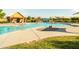 Gathering-friendly pool with splash features, seating, and a nearby pool house, surrounded by green grass at 4024 E Maplewood St, Gilbert, AZ 85297