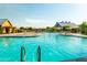 Resort-style pool with splash pad, lounge chairs, umbrellas, community buildings, and lush landscaping at 4024 E Maplewood St, Gilbert, AZ 85297