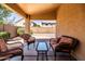 Inviting covered patio features wicker chairs and sofa, perfect for outdoor relaxation in the desert landscape at 4024 E Maplewood St, Gilbert, AZ 85297