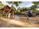 Community playground featuring slides, climbing structures, and a swing set in a sandy area at 4024 E Maplewood St, Gilbert, AZ 85297