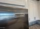 Close-up of stainless steel Frigidaire Gallery refrigerator with white cabinets and granite countertops at 4073 E Amoroso Dr, Gilbert, AZ 85296