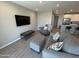 Living room with modern gray sectional and accent pillows, tile floors, and a wall-mounted TV at 4073 E Amoroso Dr, Gilbert, AZ 85296