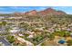 Wide aerial shot of a city neighborhood with a mountain in the background and multiple community pools at 4203 E Hazelwood St, Phoenix, AZ 85018