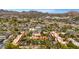 Expansive aerial view of a desert community featuring lush landscaping, vibrant homes, and picturesque mountain views at 4203 E Hazelwood St, Phoenix, AZ 85018