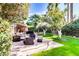 Inviting backyard patio with a cozy seating area, green grass, and lush landscaping including a citrus tree at 4203 E Hazelwood St, Phoenix, AZ 85018