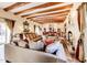 Open living room design with exposed beams, fireplace, sofa, and charming decor at 4203 E Hazelwood St, Phoenix, AZ 85018