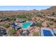 Stunning aerial view of a community pool, tennis court, and landscaping nestled in the desert, creating a resort-style ambiance at 42109 N Astoria Way, Anthem, AZ 85086