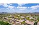 Overhead view of a residential area with mature trees, tile roofs, and views of the surrounding landscape at 42109 N Astoria Way, Anthem, AZ 85086