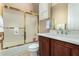 Bathroom featuring a shower-tub combo with a glass door, toilet, and vanity with a white sink at 42109 N Astoria Way, Anthem, AZ 85086