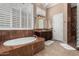 Luxurious bathroom featuring a soaking tub, marble accents, and a separate shower with glass block wall at 42109 N Astoria Way, Anthem, AZ 85086
