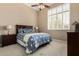 Well-lit bedroom with a ceiling fan, a bed with blue floral patterned bedding, and a window with white shutters at 42109 N Astoria Way, Anthem, AZ 85086