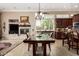 Bright dining room with stone fireplace and chandelier, seamlessly connected to the kitchen with counter seating at 42109 N Astoria Way, Anthem, AZ 85086