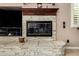 A stone fireplace with a dark wood mantle offers a focal point in the home at 42109 N Astoria Way, Anthem, AZ 85086