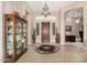 Spacious foyer featuring a hardwood front door, tile flooring, and a decorative display cabinet, creating a grand entrance at 42109 N Astoria Way, Anthem, AZ 85086