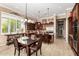 An open kitchen with dark wood cabinets, a center island and a dining table beneath a decorative chandelier at 42109 N Astoria Way, Anthem, AZ 85086