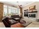 Spacious living room has a stone fireplace and large windows with wooden shutters at 42109 N Astoria Way, Anthem, AZ 85086