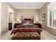 Comfortable bedroom featuring a decorative bed, nightstands, lamps, and a cozy ottoman at the foot of the bed at 42109 N Astoria Way, Anthem, AZ 85086